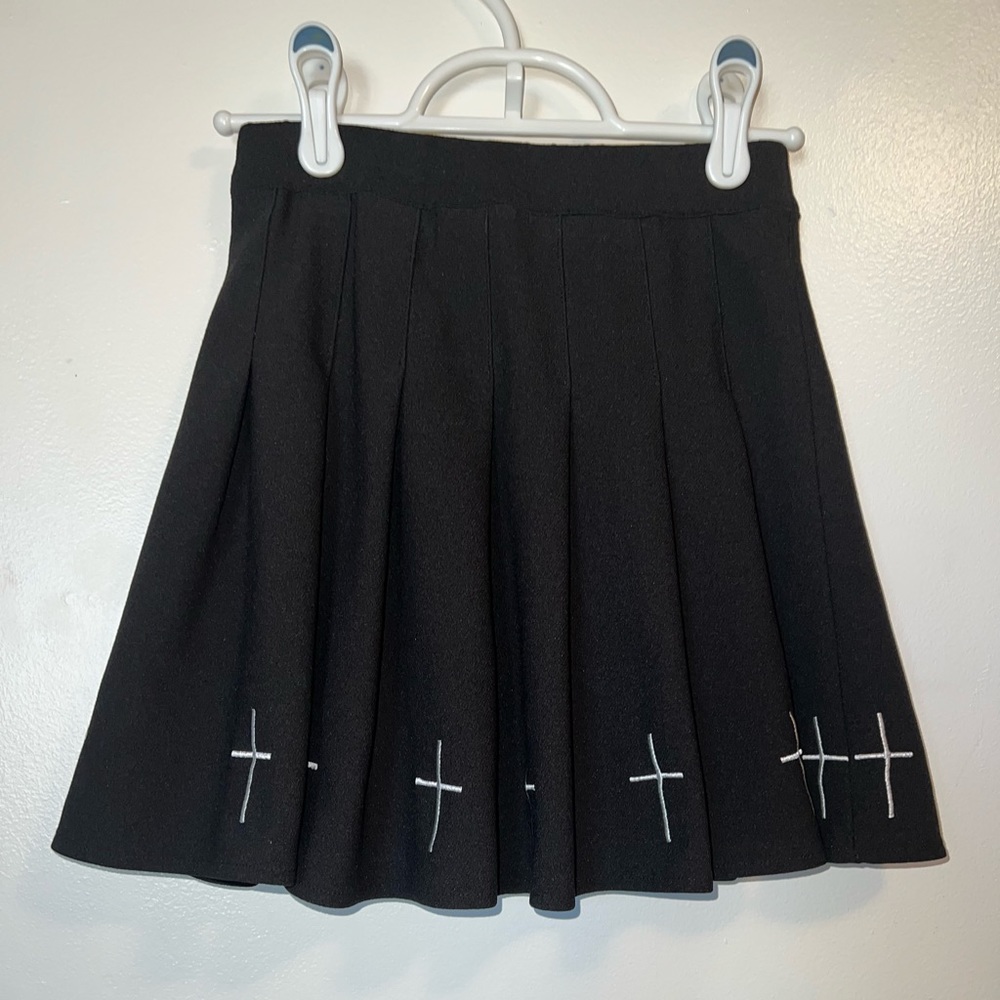 * Black pleated skirt with white crosses